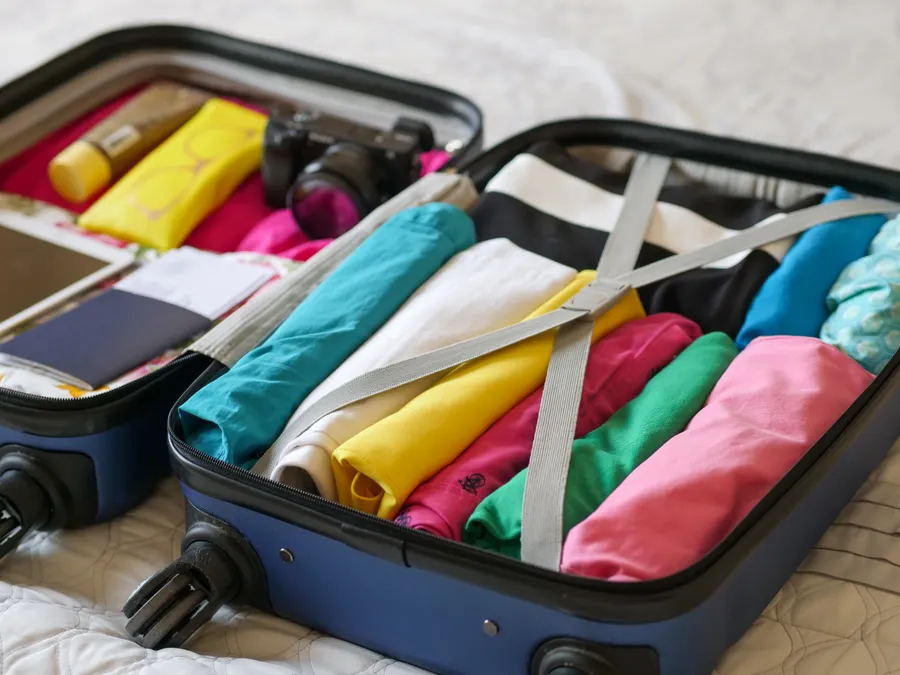 Valise ouverte, remplie de vêtements pliés et colorés